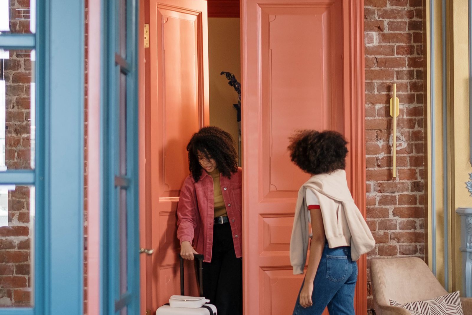 Two guests arriving at a holiday home with a suitcase
